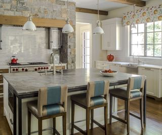 kitchen island with white pendant lights and stone surround round range cooker