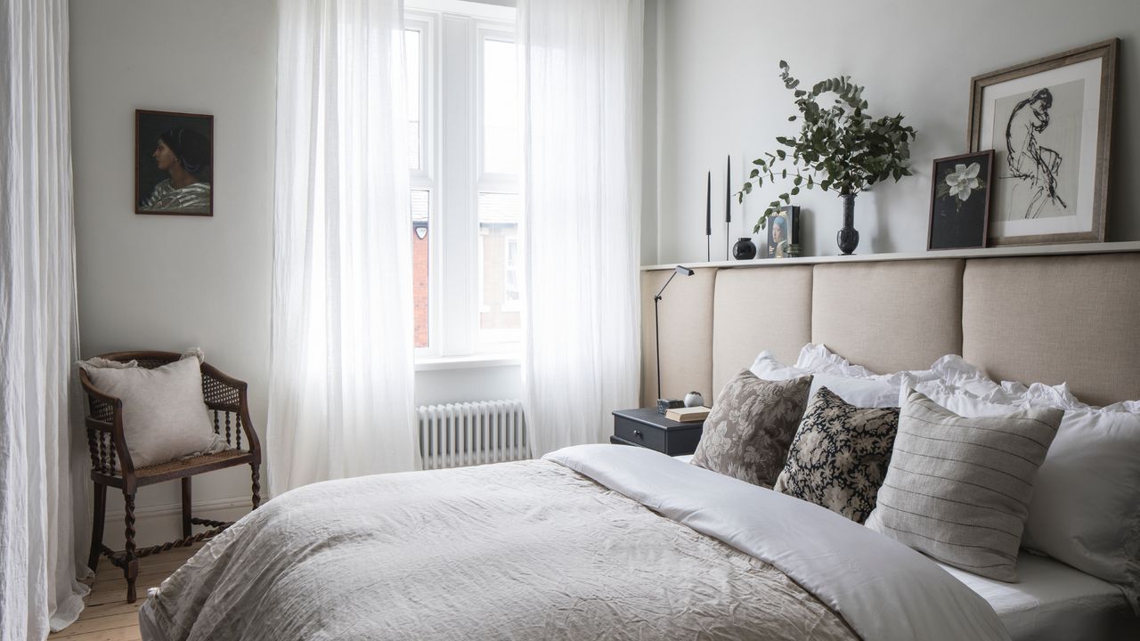 Neutral bedroom with upholstered headboard and voile curtains