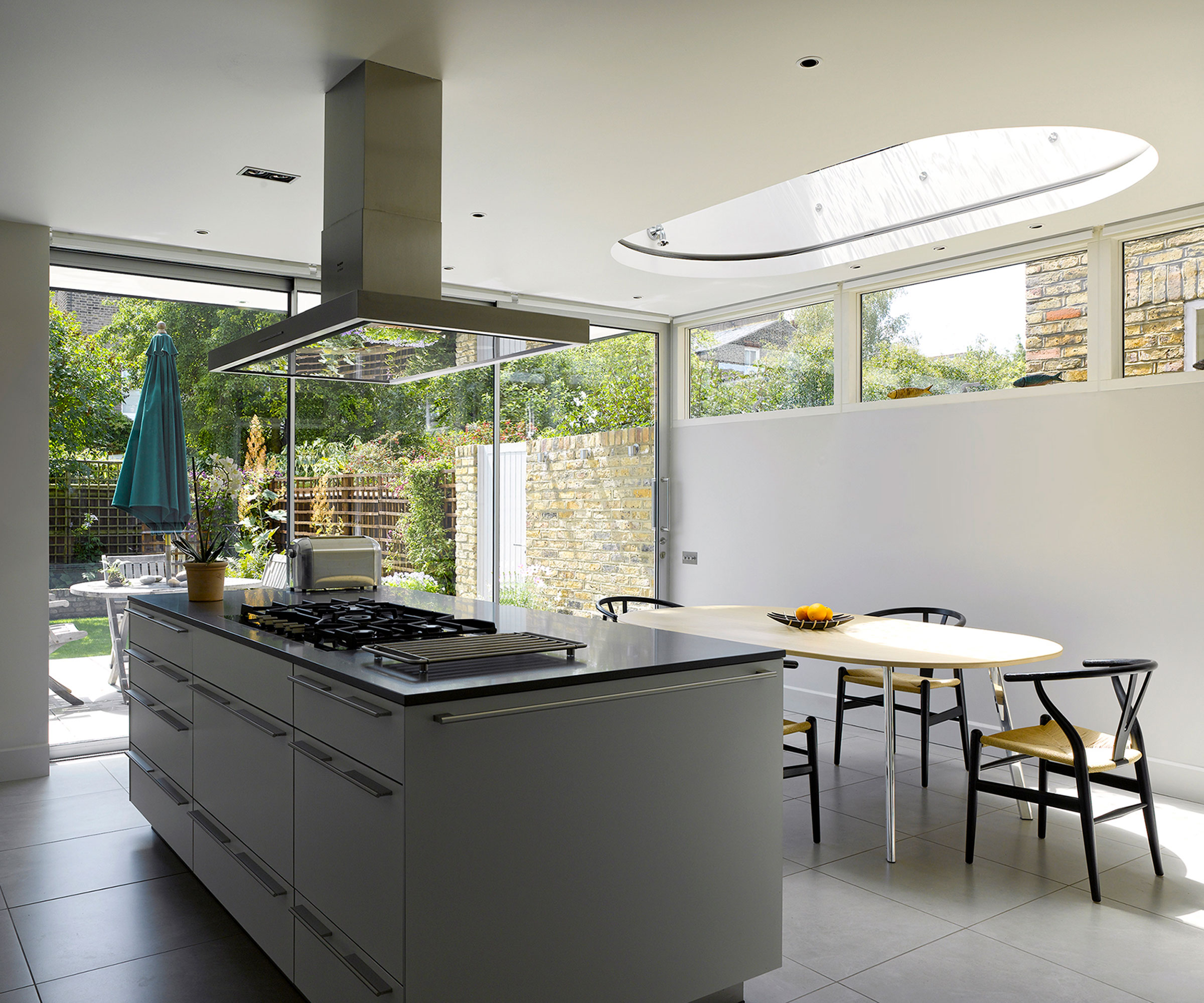 modern kitchen diner with oval roof lantern and clerestory window and sliding doors
