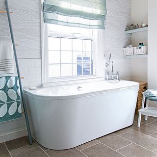 bathroom with bathtub and wallpaper with towel