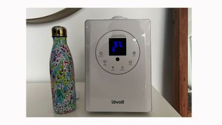 Image shows the humidifier next to a standing reusable water bottle.