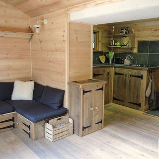 wooden living area with kitchen and navy sitting arrangement