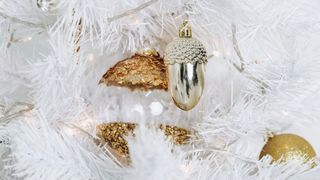 white christmas tree with gold and silver metallic tree ornaments