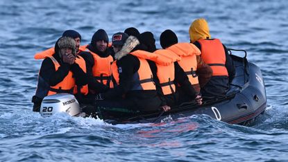 People in life jackets on a small dinghy in the English Channel