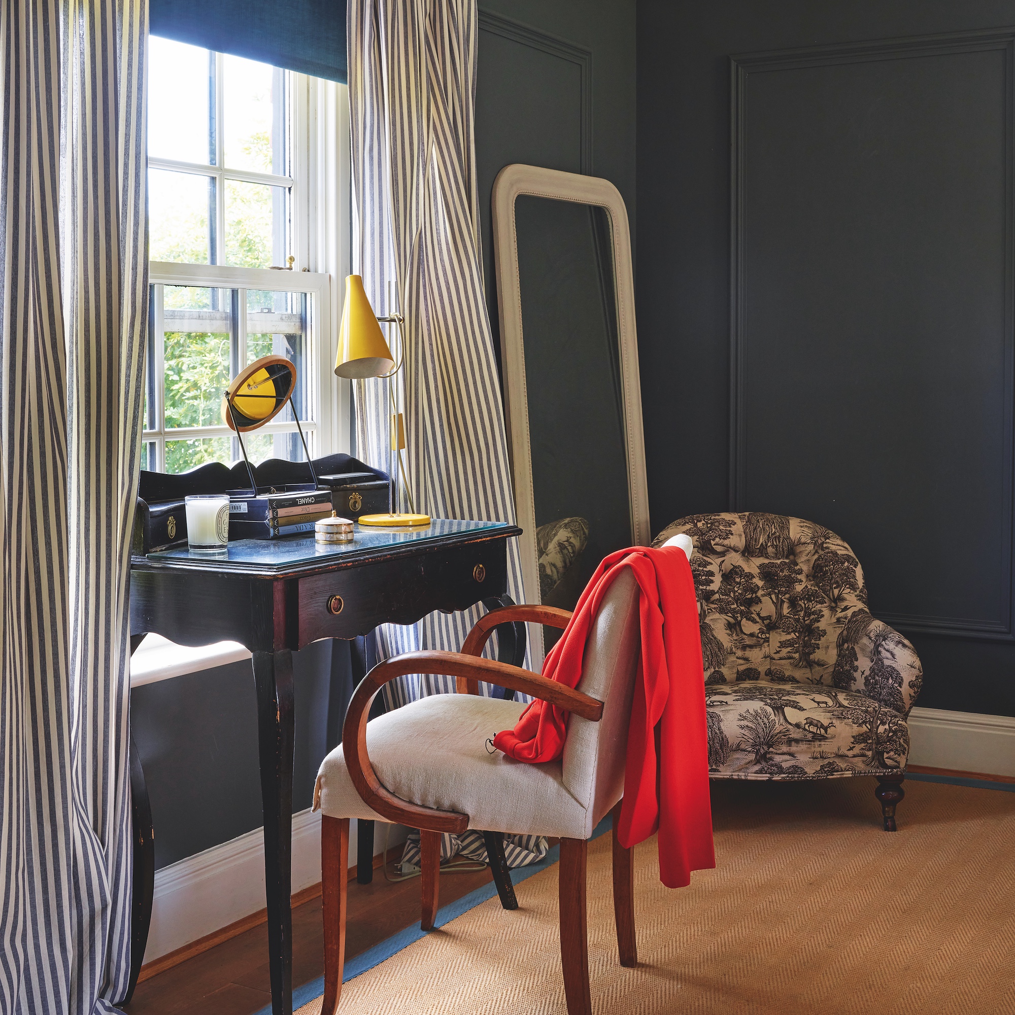 black painted bedroom with black dressing table in front of sash window