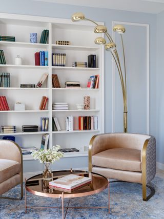 A living room corner with a book shelf and light blue walls