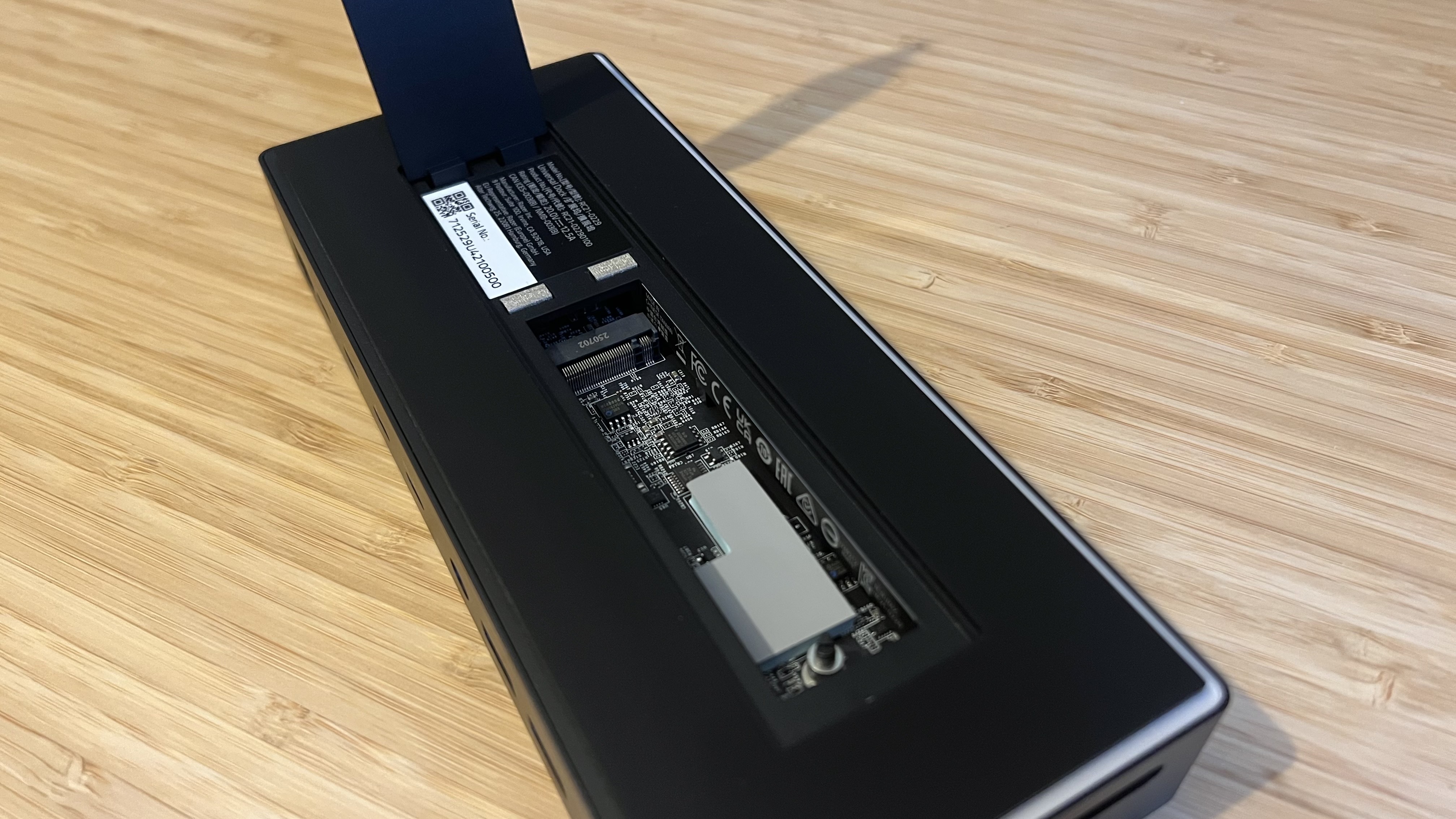 Razer Thunderbolt 5 Dock Chroma with SSD enclosure open on a wooden desk