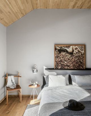 grey bedroom with wood panelled ceiling and rustic wooden furniture