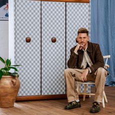 Designer Henry Holland with the Mid Century Wardrobe reupholstered with the Blenets Check Mini fabric in Atlantis from the Harlequin x Henry Holland range