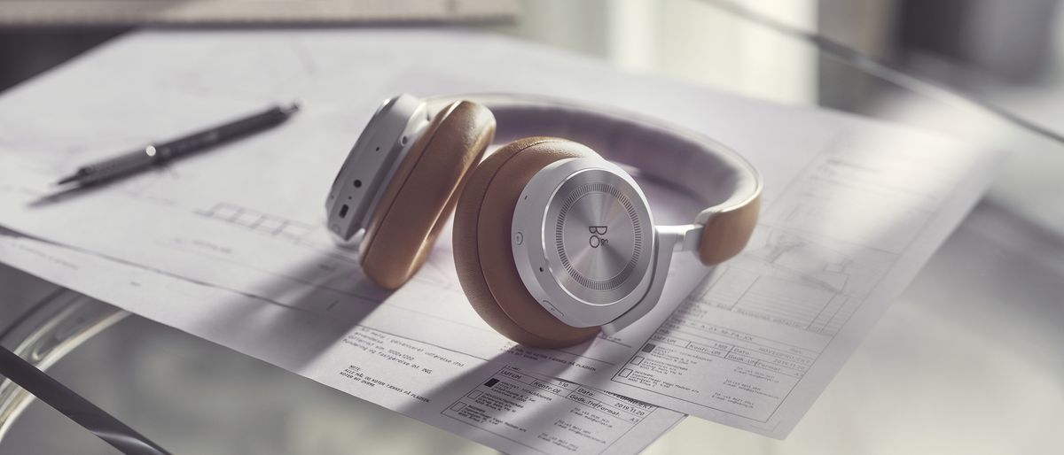 the bang &amp; olufsen beoplay hx over-ear headphones on a desk