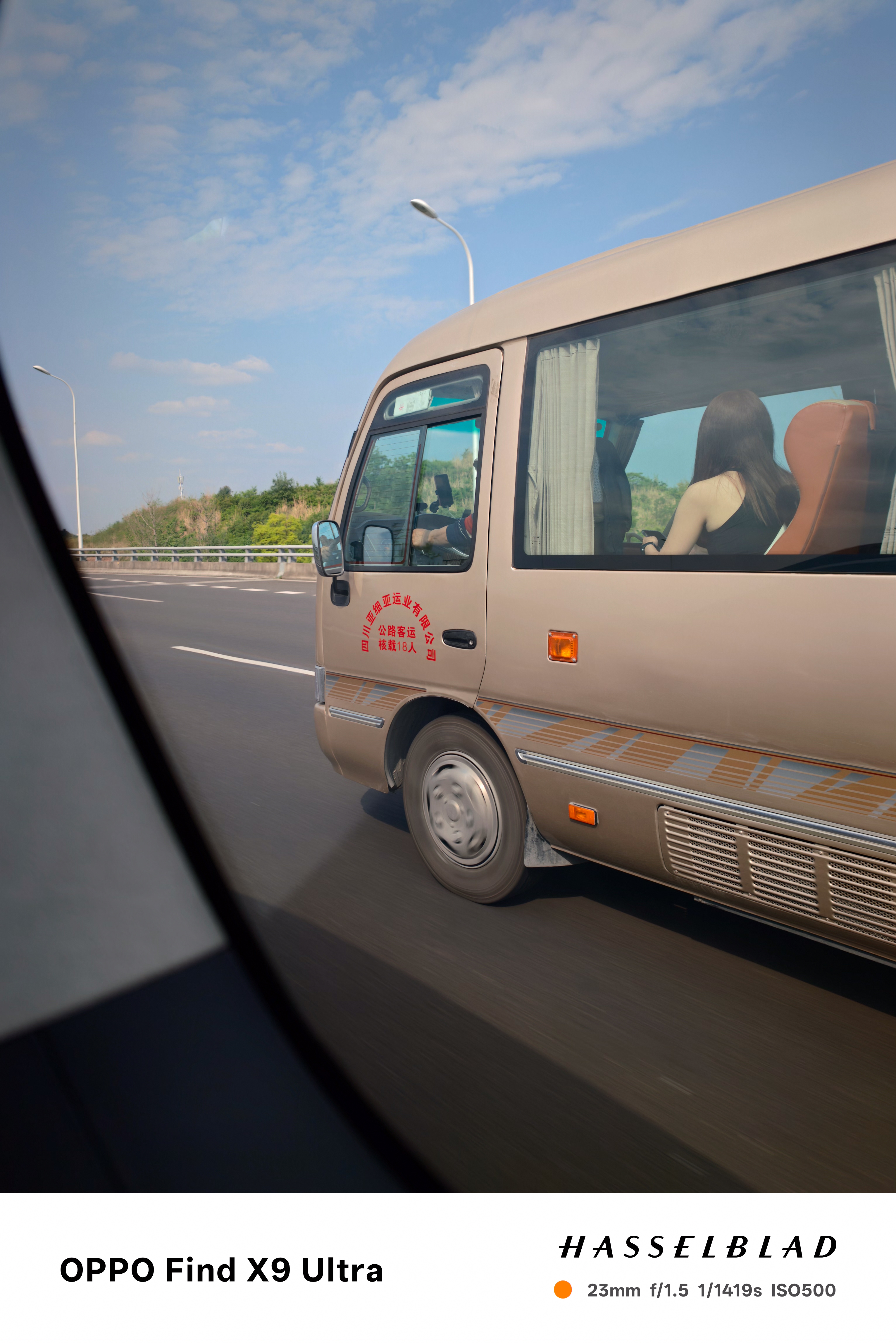 Beige minibus traveling on a highway seen from a passing vehicle