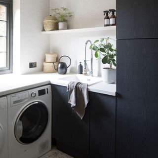 White and navy utility room with washing machine and sink