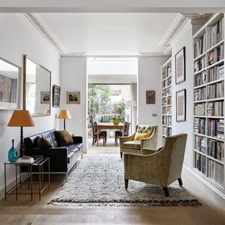 Library room with wooden flooring and black sofa