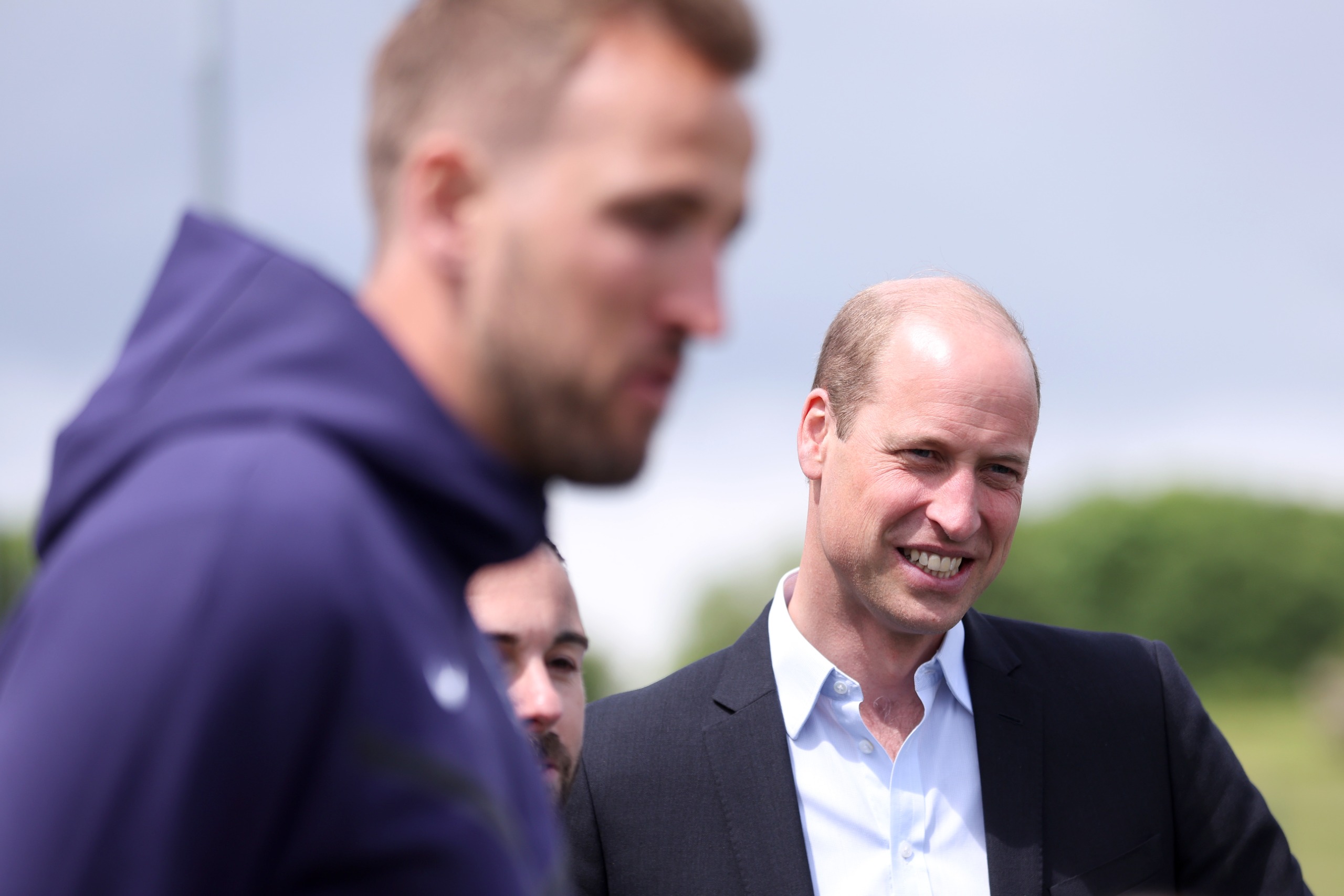 Harry Kane and Prince William, Prince of Wales, react at a youth tournament at St George's Park on June 10, 2024 in Burton upon Trent, England. 