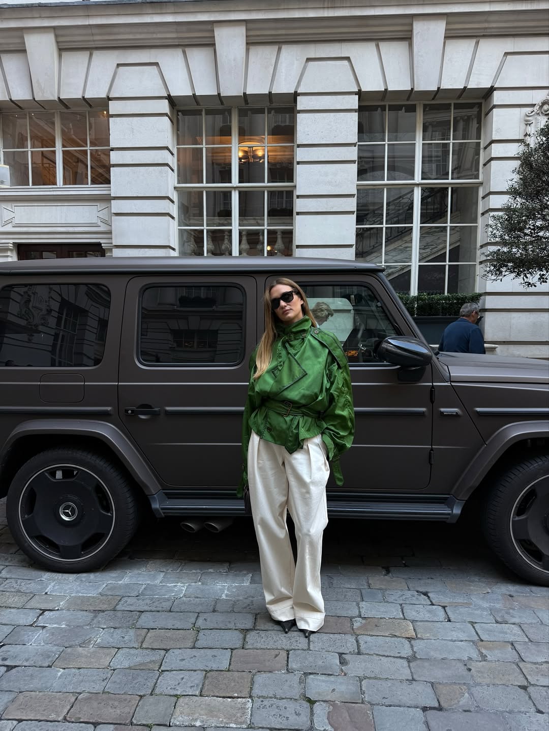 Anne-Laure Mais wearing a green funnel-neck jacket with ivory trousers in Paris