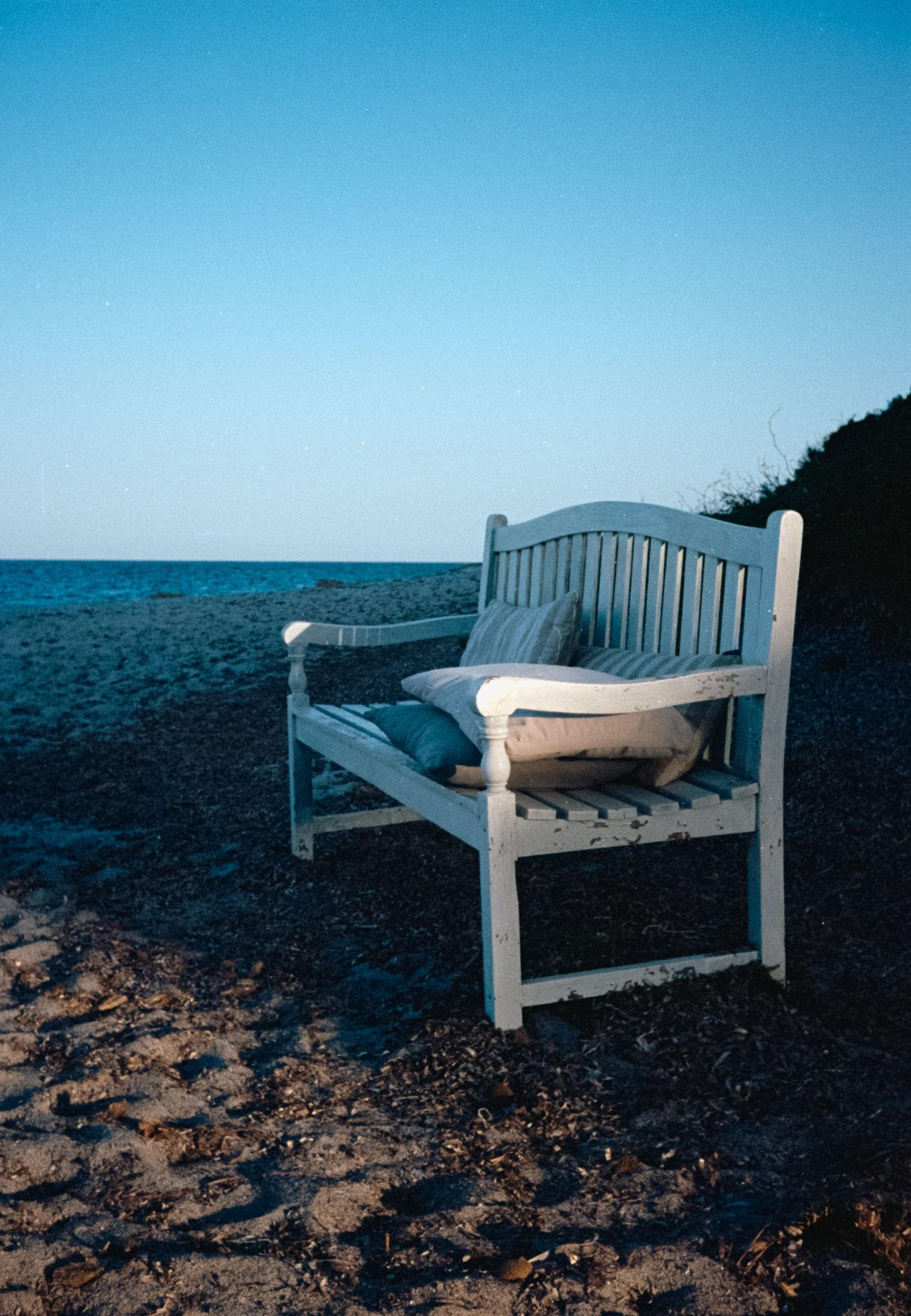 Bench with cushions on it on a beach