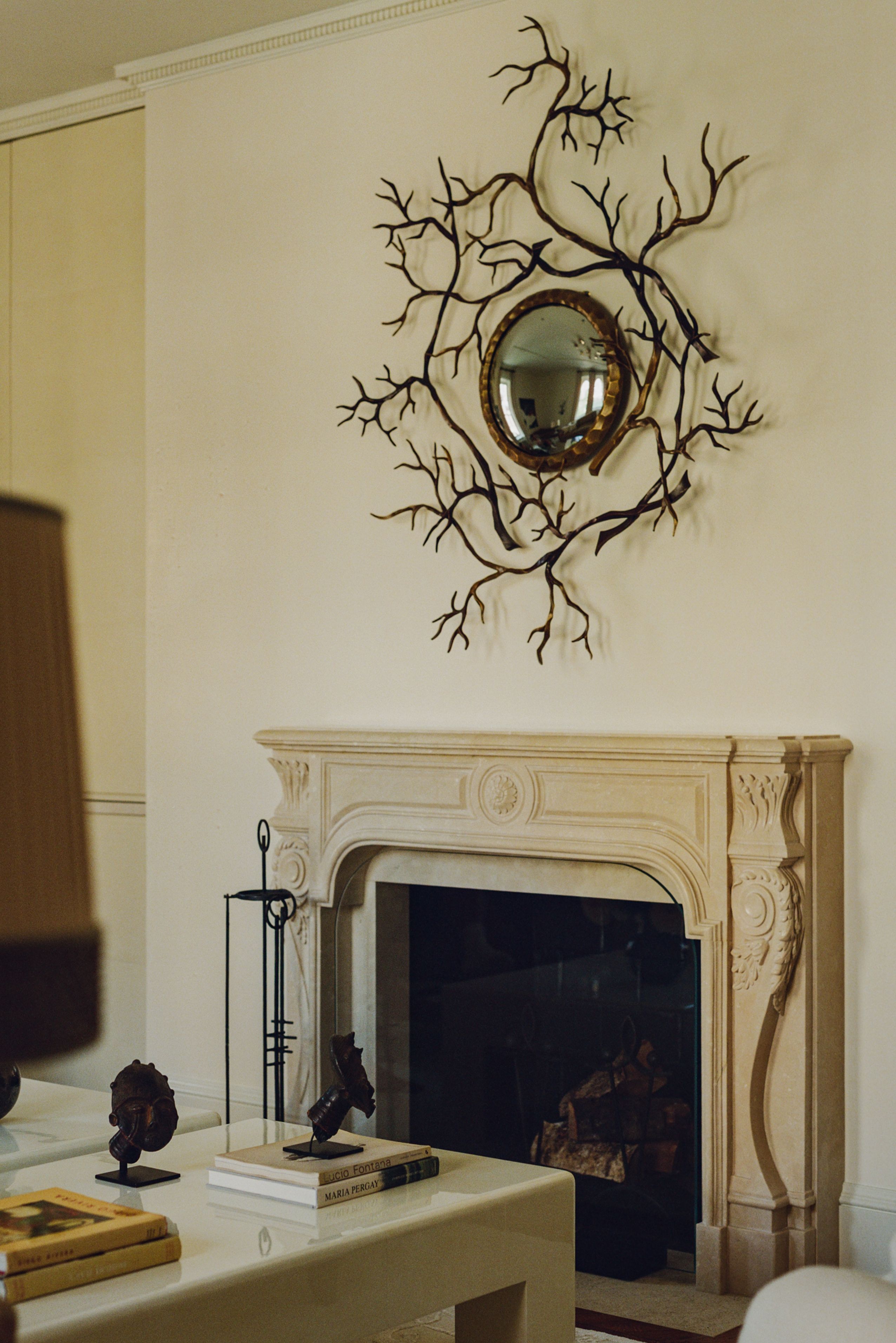 a mirror on a wall with a decorative branch like effect
