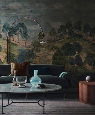 A moody living room with a large blue and green mural, a sofa and a floor lamp