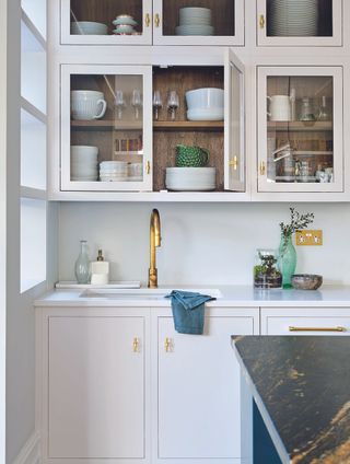 how to create more storage in a small kitchen with white cabinets and brass taps
