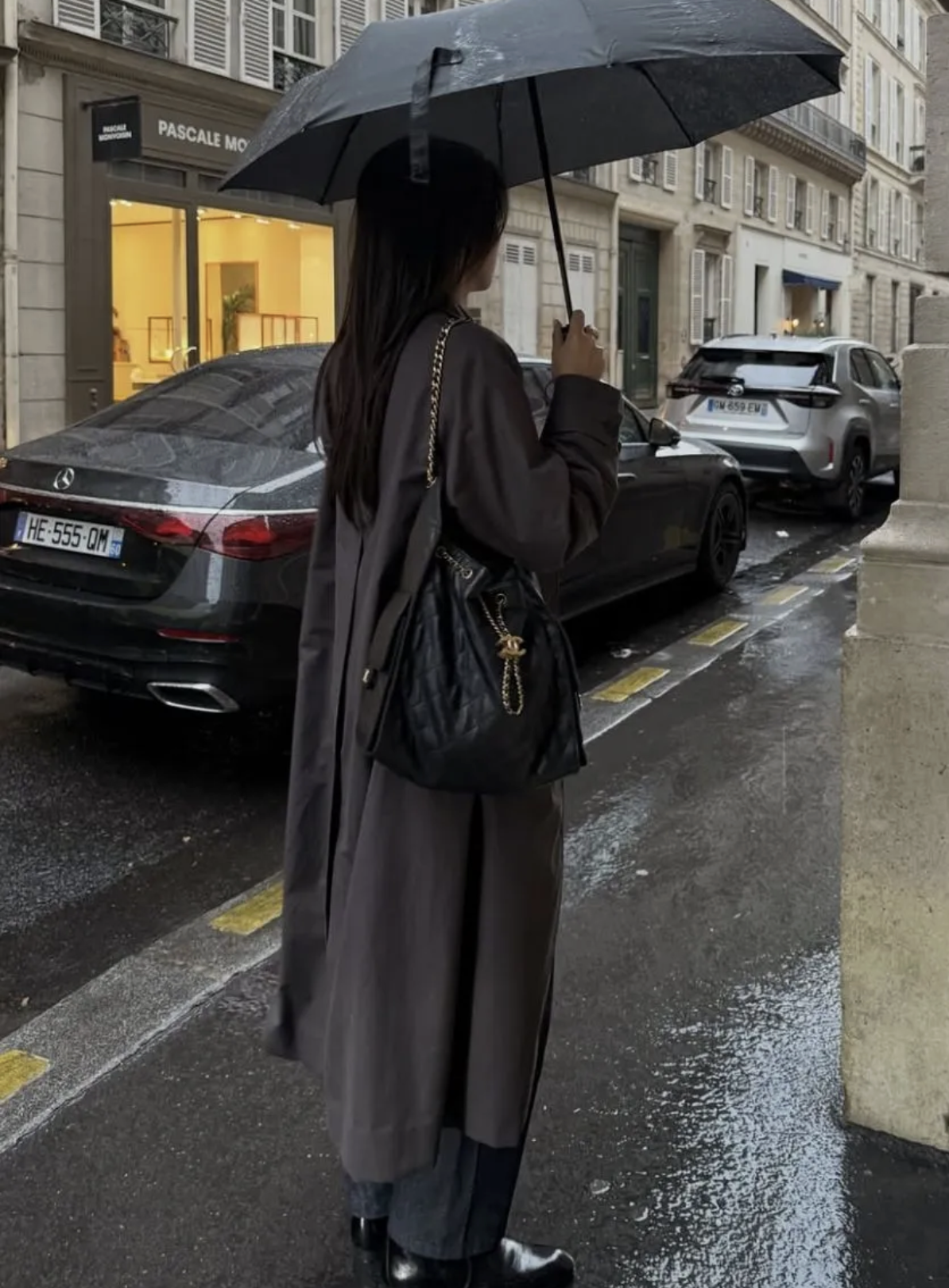 A woman in the rain holding an umbrella