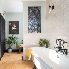Moroccan inspired small bathroom with terracotta floor tiles and decorative tiled walls