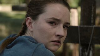 A close up of Kaitlyn Dever's Abby looking back at the camera in The Last of Us season 2