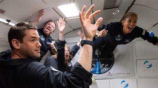 four people in flight suits floating in a plane