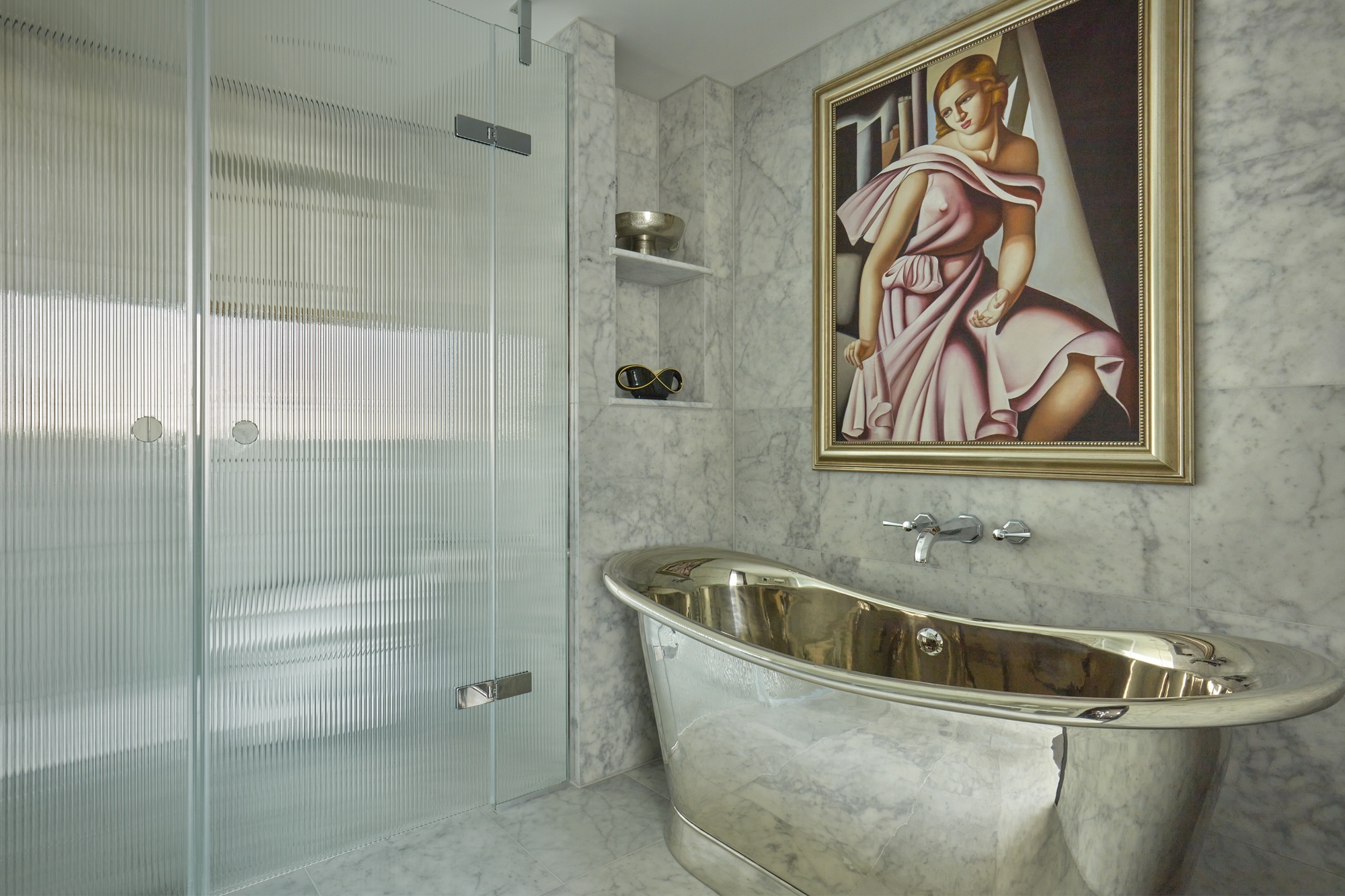 a marble art deco bathroom with stainless steel finishes and a reeded glass shower screen
