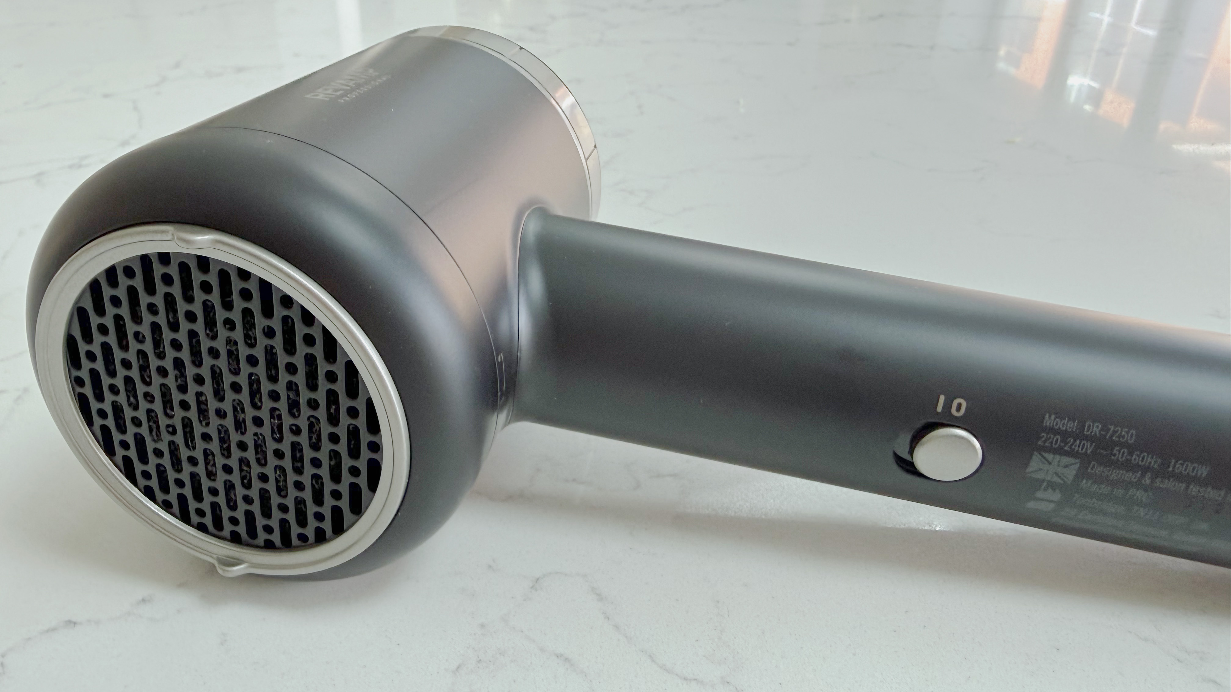 Rear view of the Revamp Tri-Care hair dryer showing the air intake, power switch, and heat and speed controls