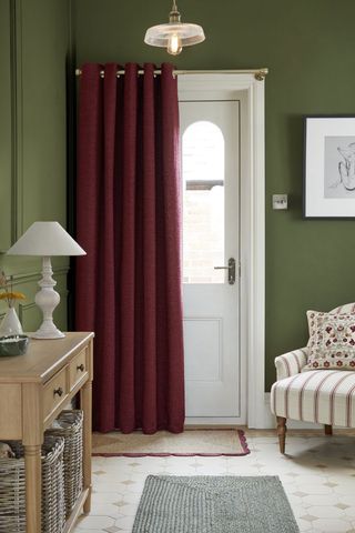 hallway with green walls, red curtain and wooden console