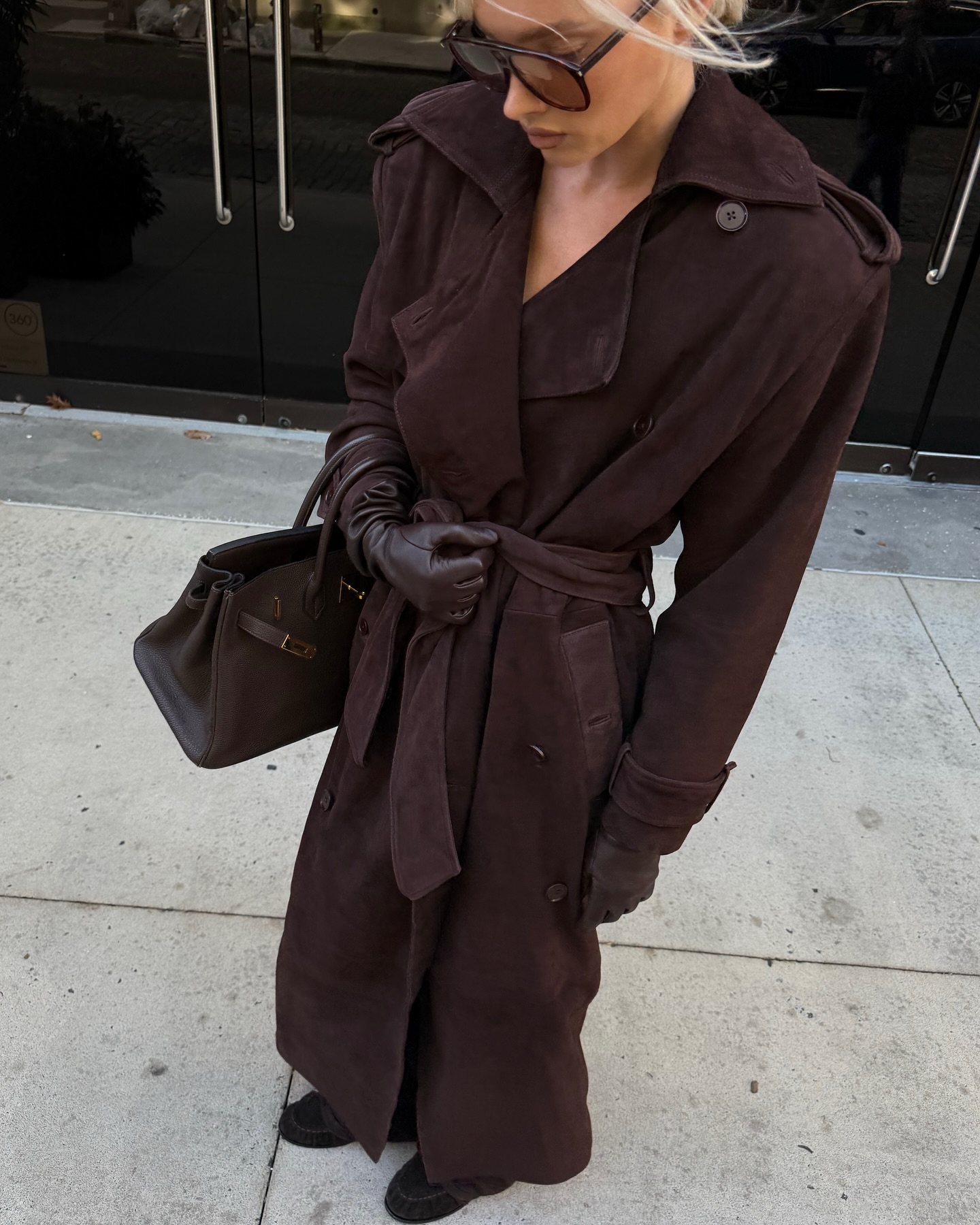 Elsa Hosk with a brown suede gabardine with a black bag and gloves.