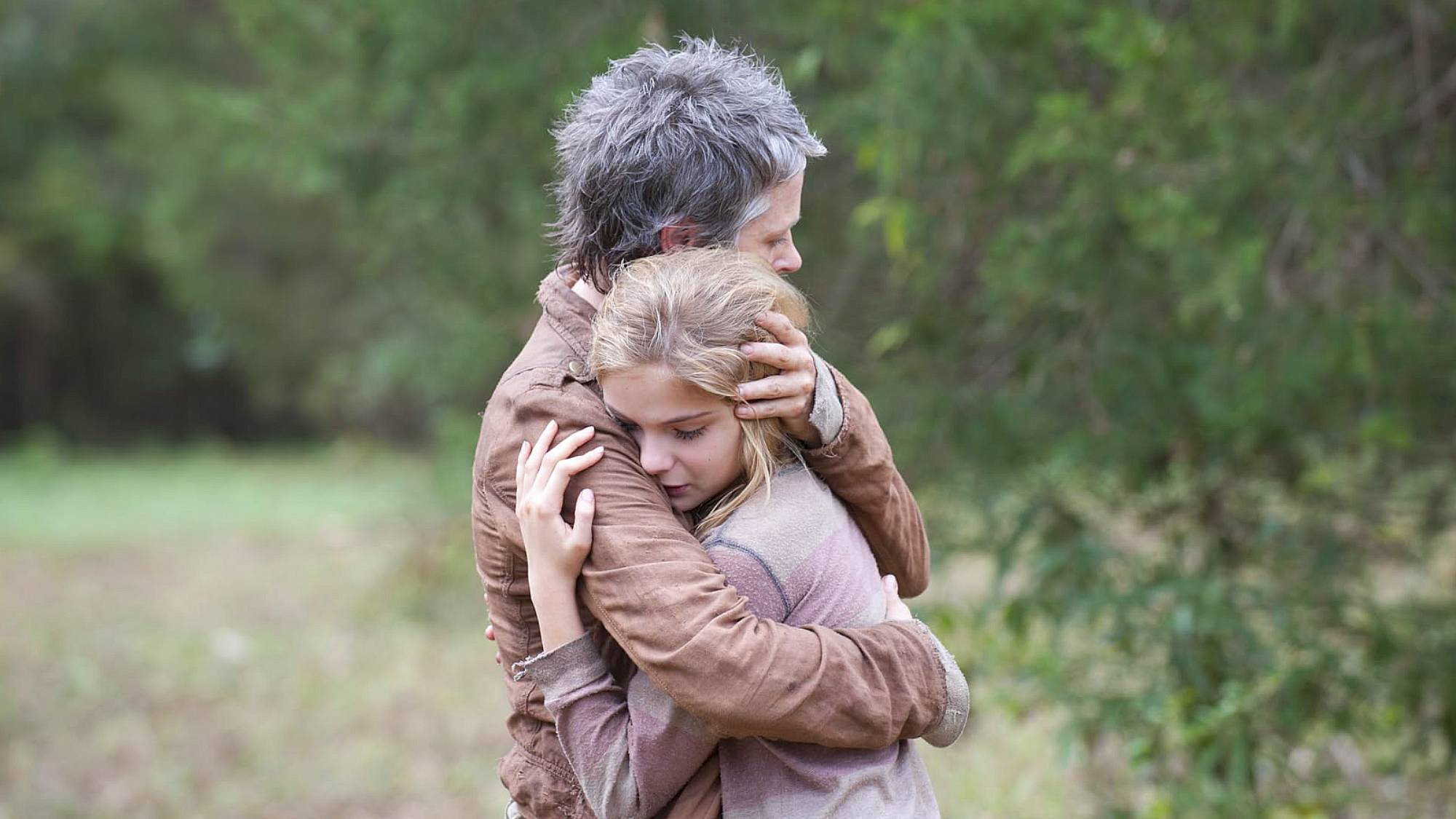 Melissa McBride as Carol and Brighton Sharbino as Lizzie hugging during a sad moment in "The Walking Dead" season 4 episode 14, titled "The Grove"
