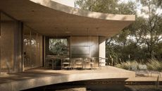 A hyper-stylish garden near an under-flowing water feature with a chrome dining set and a set of metal daybeds