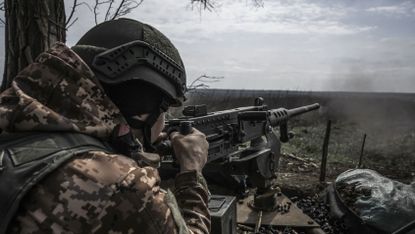 A Ukrainian soldier using a gun on the front line of in the war against Russia