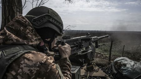 A Ukrainian soldier using a gun on the front line of in the war against Russia