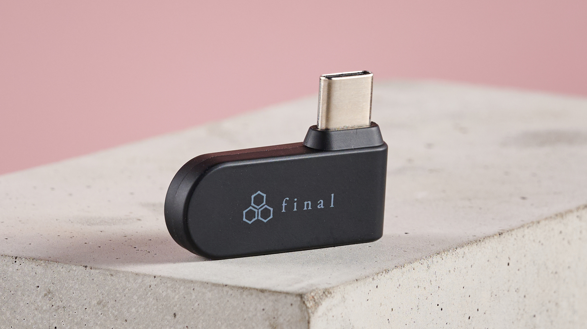 USB dongle for Final VR3000 Wireless earbuds on plinth with pink background