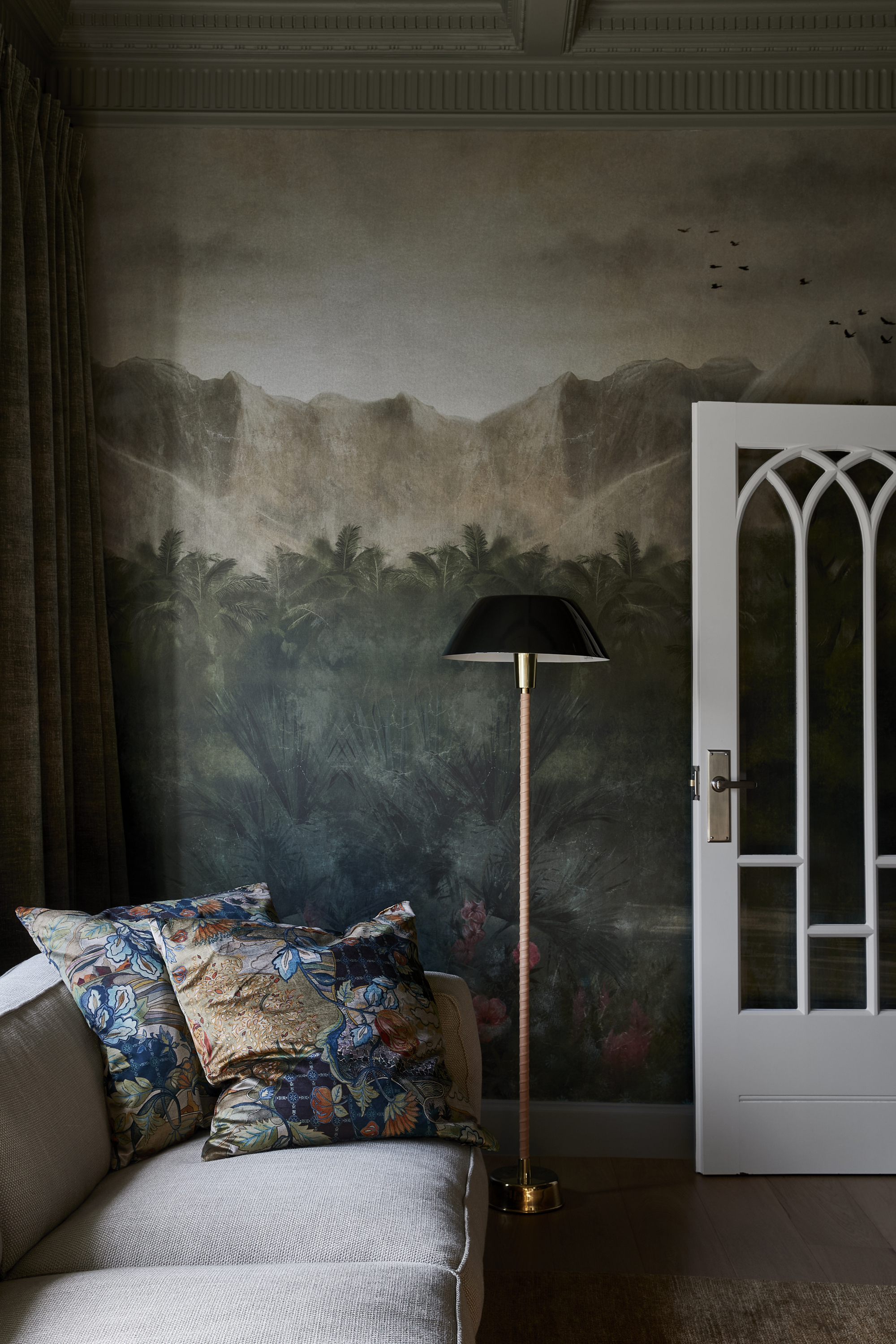 green and gray living room with wall mural, white french door, floor lamp, gray sofa and colorful throw pillows styled on the end