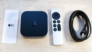 The Apple TV 4K (2022) box's contents: a pamphlet, the Apple TV 4K (2022), the Siri remote and power cable.