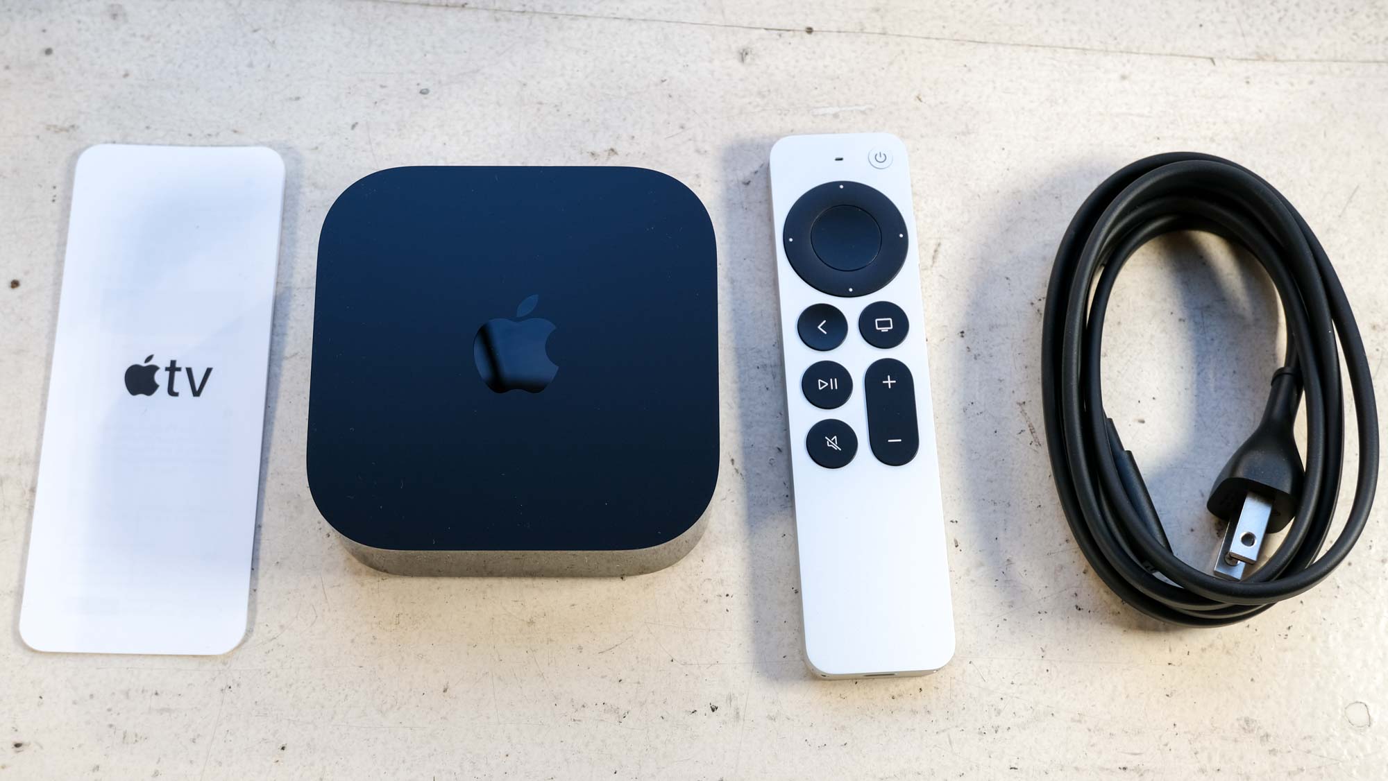 The Apple TV 4K (2022) box's contents: a pamphlet, the Apple TV 4K (2022), the Siri remote and power cable.