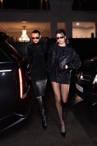 Bella Hadid and Hailey Bieber arrive holding hands at Zoe Kravitz's house in Paris for the Saint-Laurent after-party at Paris Fashion Week on March 11.