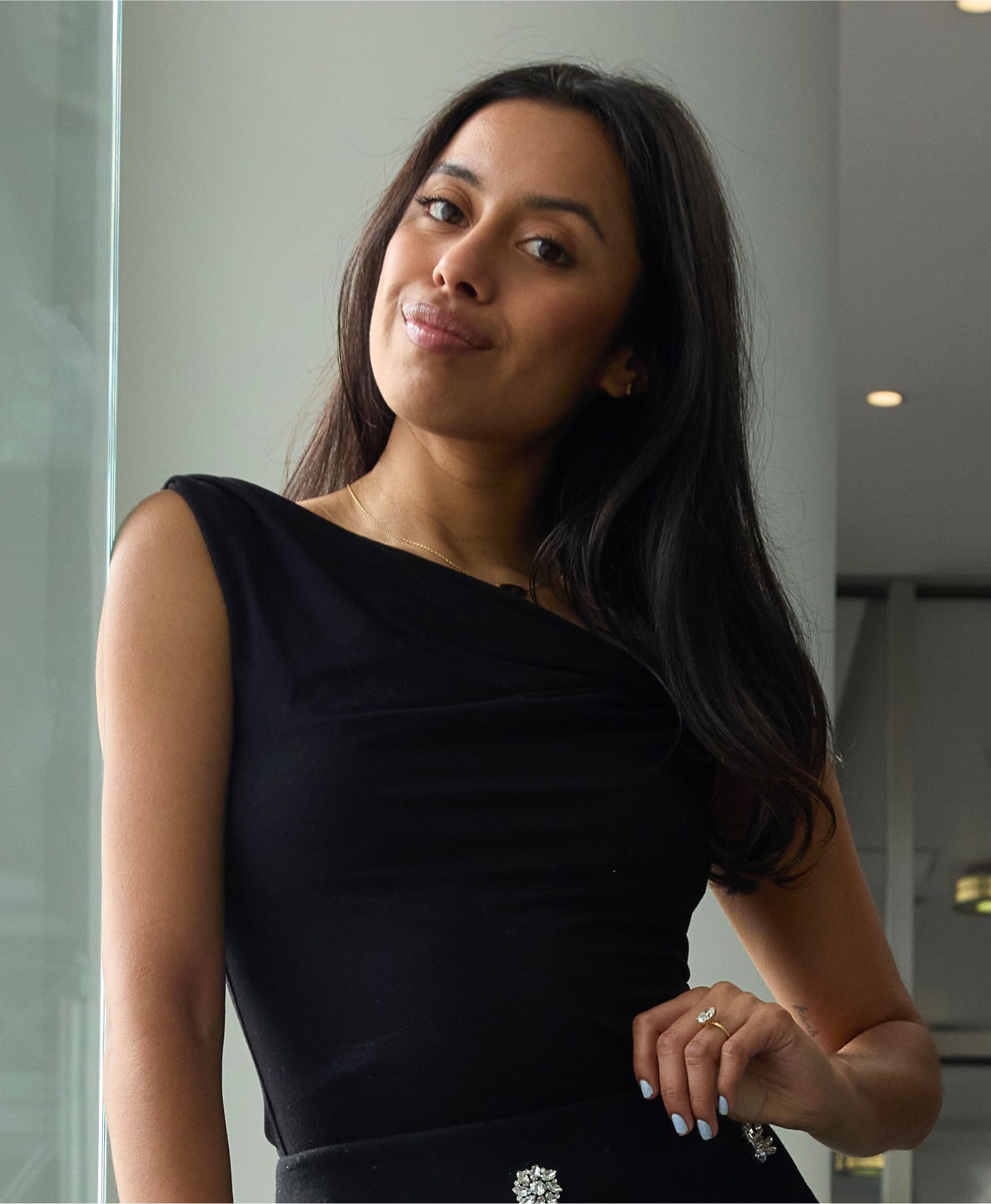 a brown woman with long dark hair. ina deep plum top