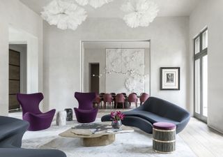 living room dining room combo with purple curved sofa and dining table through an archway