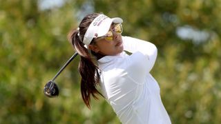 Alison Lee holding the finish after hitting a fairway wood