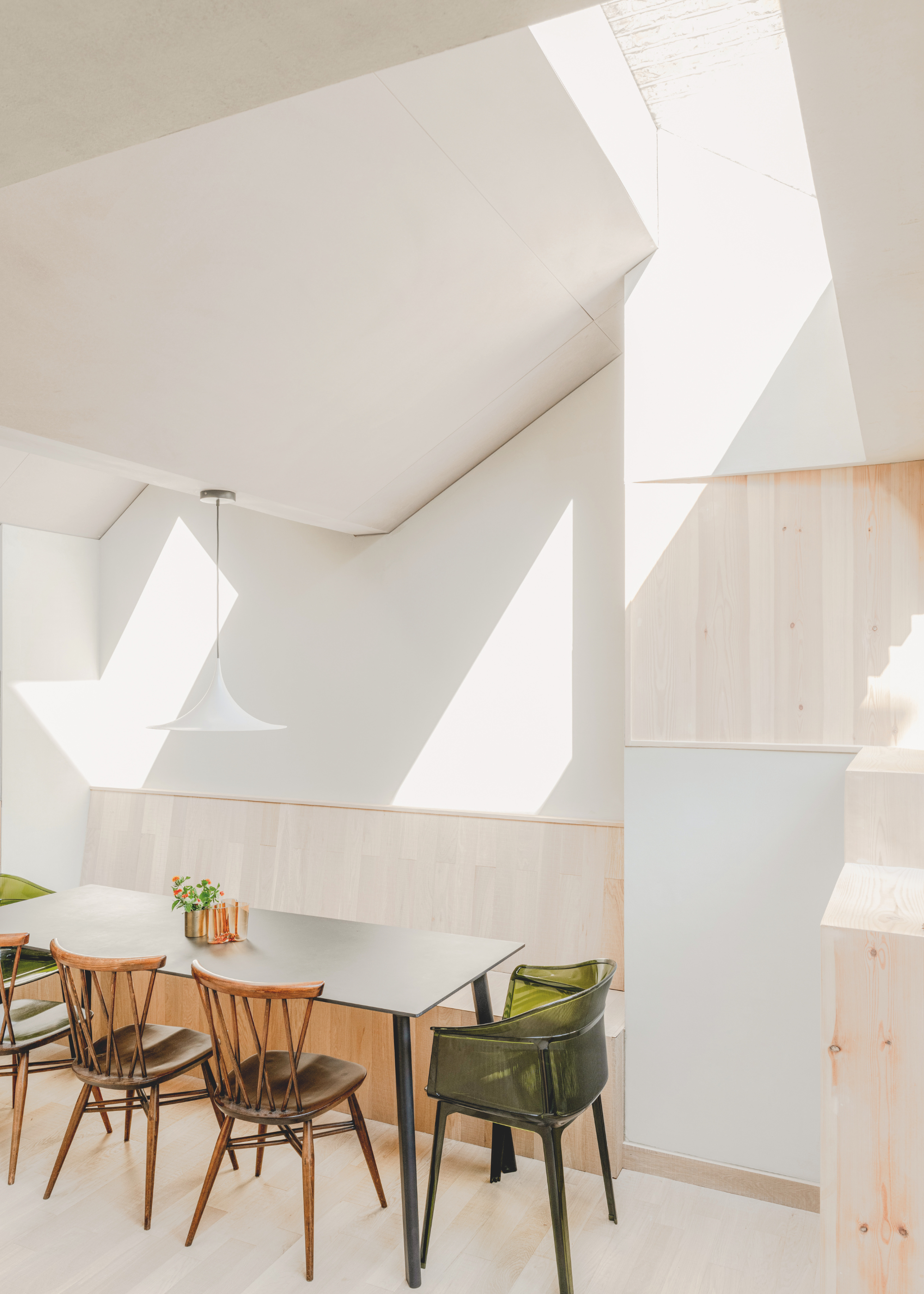 A light dining area with pale wooden cladding and vaulted ceiling.