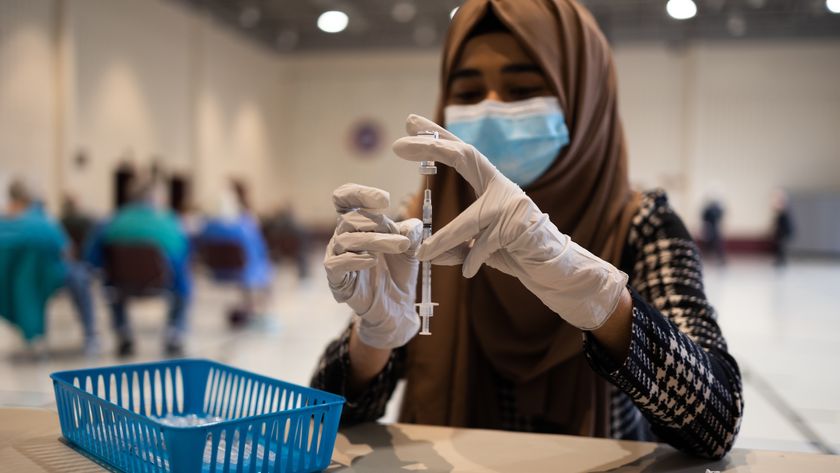 a healthcare worker prepares a vaccine dose