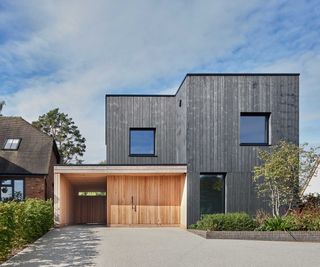 contemporary black timber-clad self-build with large driveway