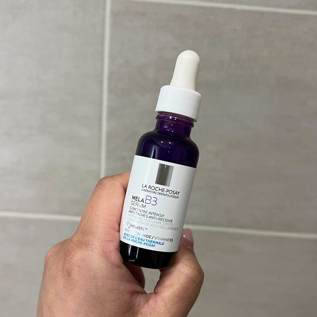 Hand holding purple jar of La Roche-Posay MelaB3 Serum Intense Anti-Dark Spot Serum for Hyperpigmentation