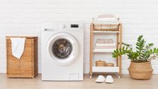 Getty Images washing machine with wooden and rattan laundry bin, shelving and plant pot