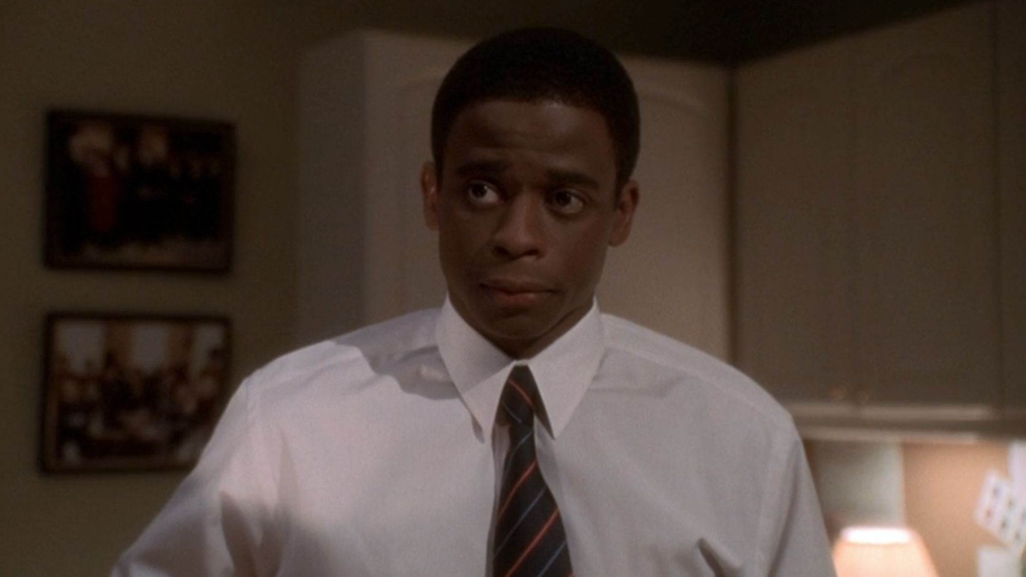 Dule Hill as Charlie Young on The West Wing, wearing a white shirt and tie, looking stunned. 