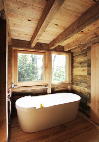 cabin bathroom with a tub overlooking outdoors